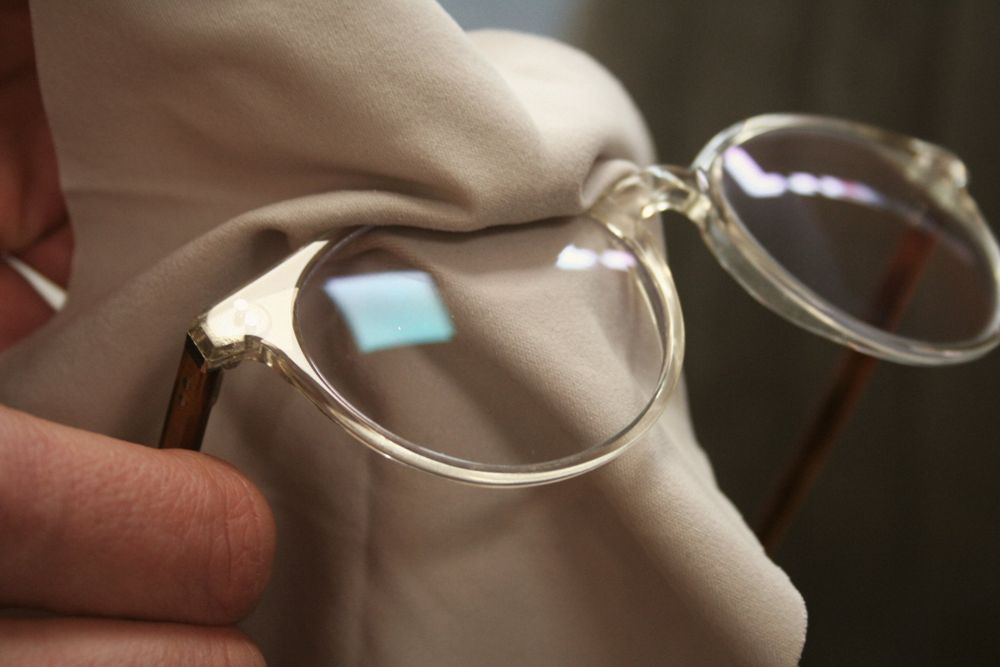 Eine Brille wird mit einem Tuch gereinigt.