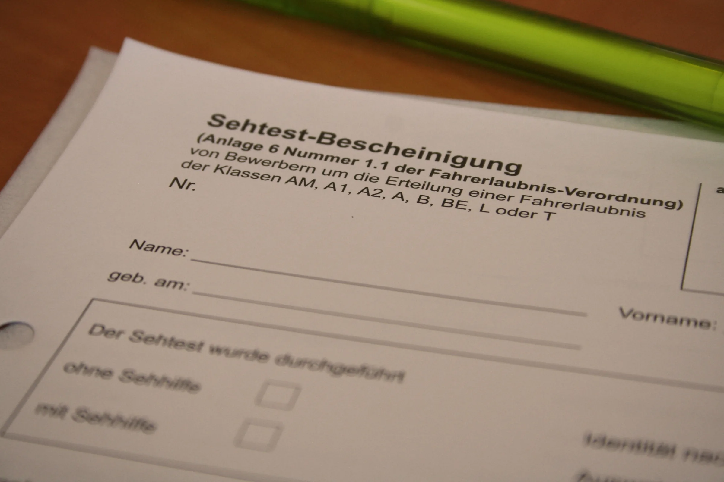 Ein leeres Formular „Sehtest-Bescheinigung“ für die Fahrerlaubnis liegt auf einem Tisch.
